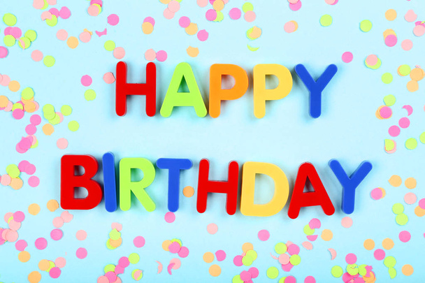 Text Happy Birthday by plastic letters with confetti on blue bac - 写真・画像