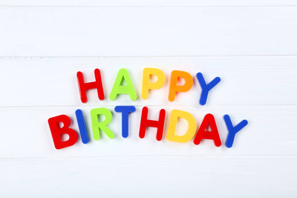 Text Happy Birthday by plastic letters on white wooden table - 写真・画像