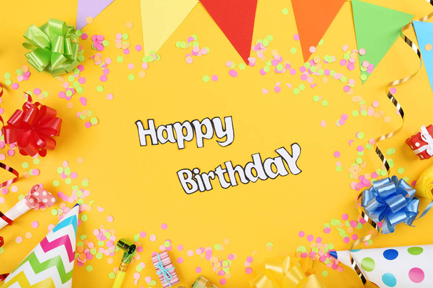 Text Happy Birthday with party decorations on yellow background - Fotografie, Obrázek