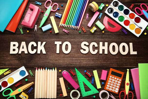 Inscription Back To School with school supplies on wooden table - Φωτογραφία, εικόνα
