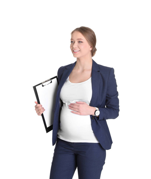 Young pregnant woman in suit with clipboard on white background. Working while expecting baby - Fotografie, Obrázek