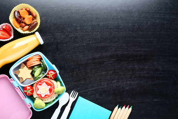 School lunch box with sandwich and vegetables on blackboard back - Foto, Imagen