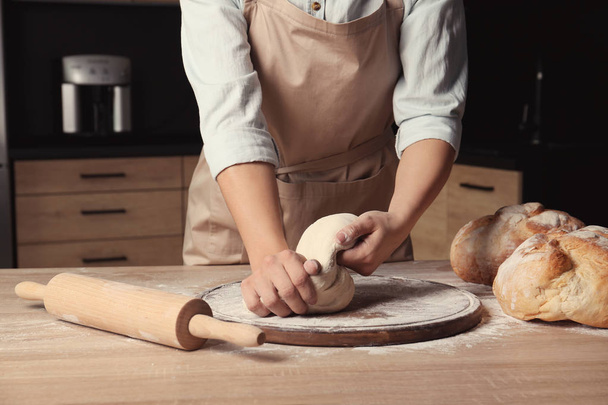 Female baker preparing bread dough at table, closeup - Foto, Imagen