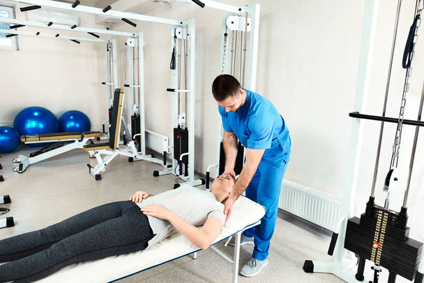 Physiotherapist working with patient in rehabilitation center - Fotó, kép