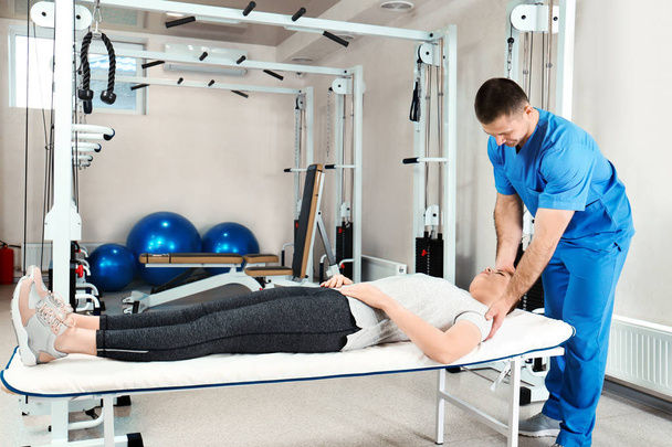 Physiotherapist working with patient in rehabilitation center - Foto, Bild