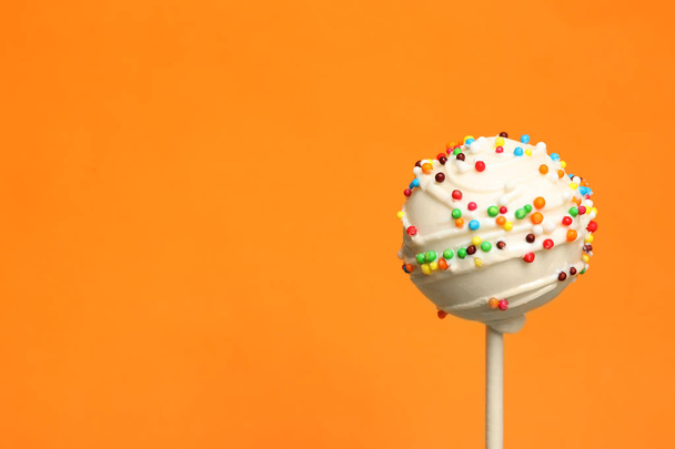 Bright delicious cake pop on color background. Space for text - Valokuva, kuva