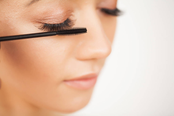 Eyelashes extensions. Fake Eyelashes. Eyelash Extension Procedure. Professional stylist lengthening female lashes. Master and a client in a beauty salon - Photo, Image