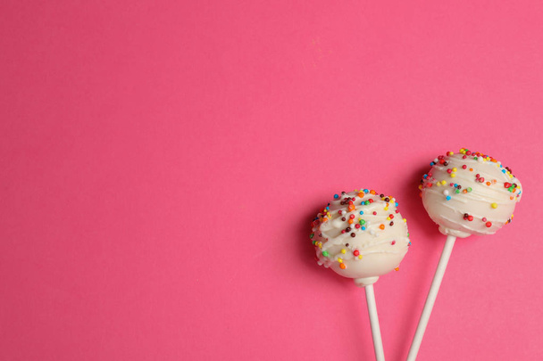 Bright delicious cake pops on color background, flat lay. Space for text - Foto, afbeelding