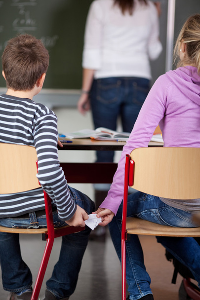 Children Passing Cheat In Examination At Classroom - Valokuva, kuva