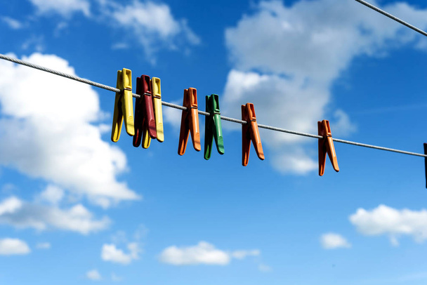 Diverse heldere plastic kleren pinnen op een waslijn  - Foto, afbeelding