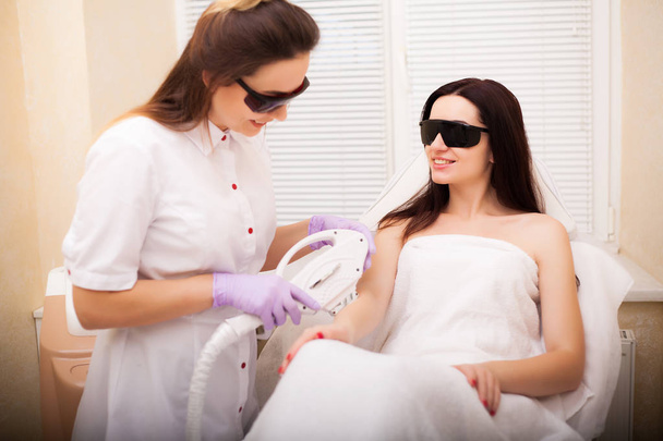 Hautpflege. Erwachsene Frau mit Laser-Haarentfernung in professionellem Schönheitssalon - Foto, Bild