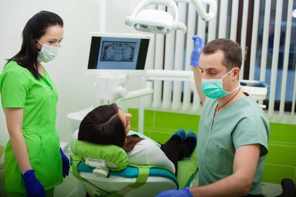 Paciente en odontología. Mujer bonita visitando a su dentista en la clínica
 - Foto, Imagen