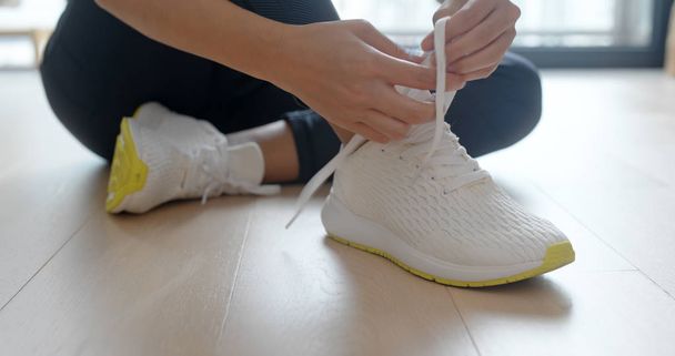 Woman wearing sport shoes at home - Foto, imagen