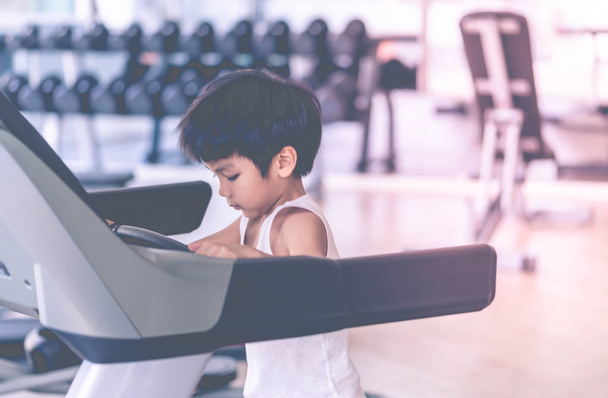 Asian dziecko działa na bieżni w siłowni fitness - Zdjęcie, obraz