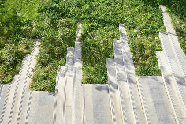La escalera en el parque está forrada con losas de granito con escalones sobresalientes a la izquierda
. - Foto, imagen