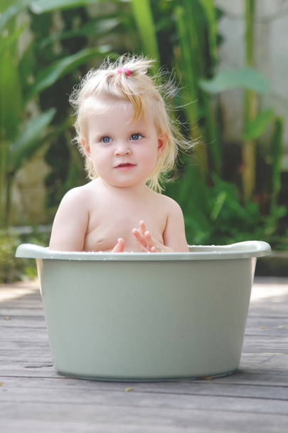 Plastik bir kova içinde bebek banyo, yaz gününde samimi açık portre - Fotoğraf, Görsel