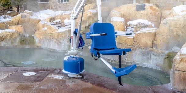 Sedia blu collegata a un braccio di metallo bianco vicino a una piscina di wa caldo
 - Foto, immagini
