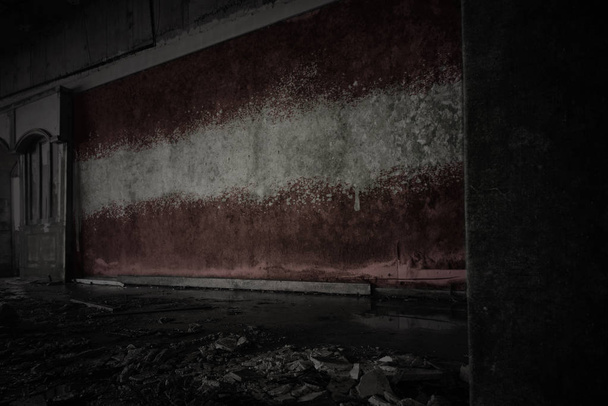 bandera pintada de latvia en la pared vieja sucia en una casa arruinada abandonada
. - Foto, Imagen
