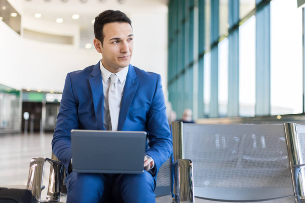 Young businessman working with his laptop in an airport - Photo, image