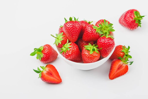 Red ripe strawberry in the white bowl, light background - Foto, imagen