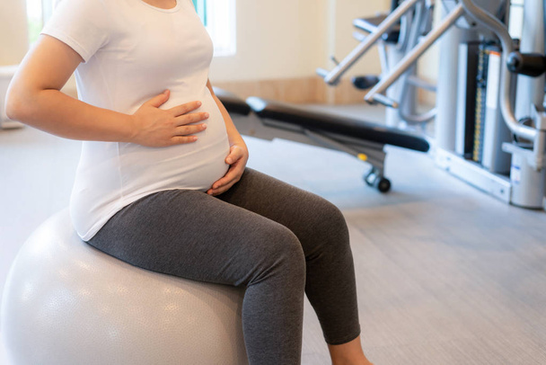 Active pregnant woman exercise in fitness center. - Foto, Imagen