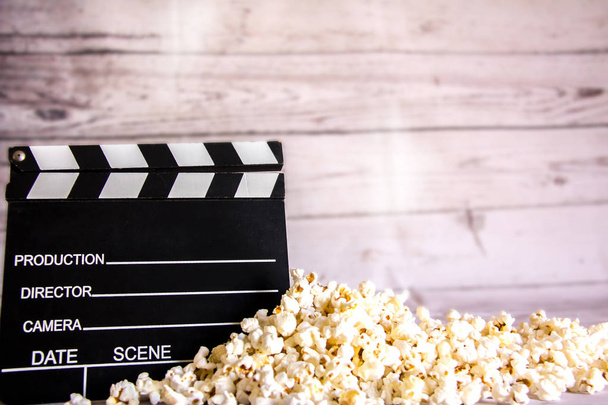 Popcorn et clapperboard sur fond de bois blanc pour fond de cinéma
 - Photo, image