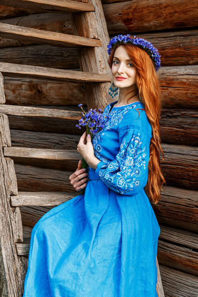 Beautiful red-haired girl in a blue dress (Ukrainian) with a wre - Foto, Imagem