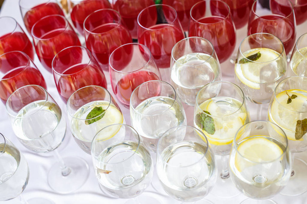 lot of blurred glasses with red and white wine on the reception party table  - Foto, afbeelding