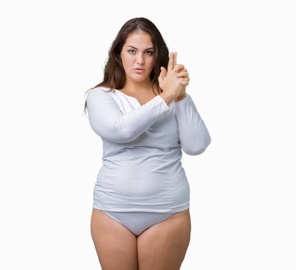Beautiful plus size young overwight woman wearing white underwear over isolated background Holding symbolic gun with hand gesture, playing killing shooting weapons, angry face - Fotó, kép