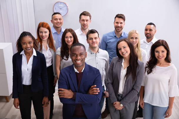 Group Of Young Successful Multi-ethnic Businesspeople Standing In Office Looking At Camera - Foto, Imagem
