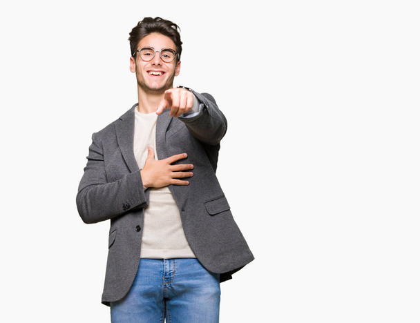 Молодий бізнесмен в окулярах над ізольованим тлом Сміється з вас, вказуючи на камеру пальцем рукою по грудях, сором виразом
 - Фото, зображення