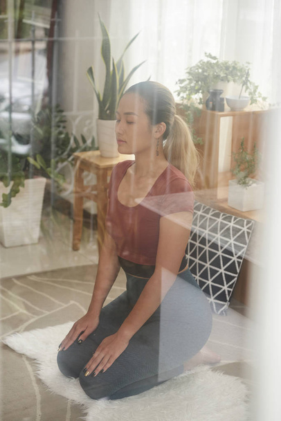 Young Vietnamese woman practicing morning meditation to release stress - Photo, Image