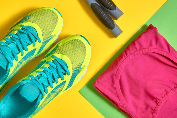 Sport shoes, female top bra and skipping rope on colorful yellow - Valokuva, kuva