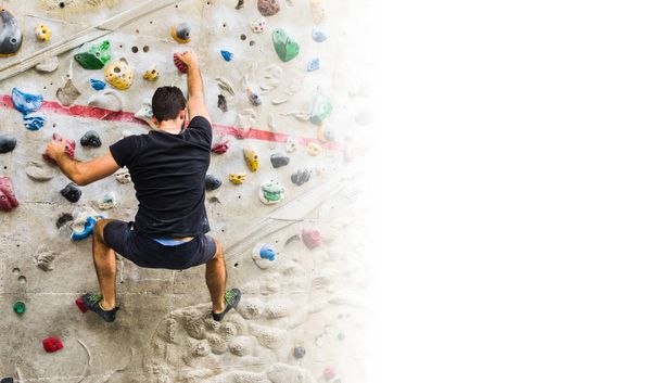 Hombre practicando escalada en roca en paredes artificiales en interiores. Activo
  - Foto, imagen