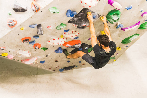 Man practicing rock climbing on artificial wall indoors. Active  - Fotografie, Obrázek