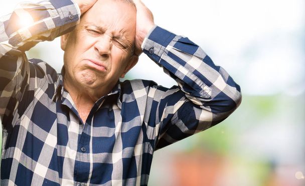 Knappe Senior man het dragen van casual shirt lijdt aan hoofdpijn wanhopig en gestrest omdat pijn en migraine. Handen op het hoofd. - Foto, afbeelding