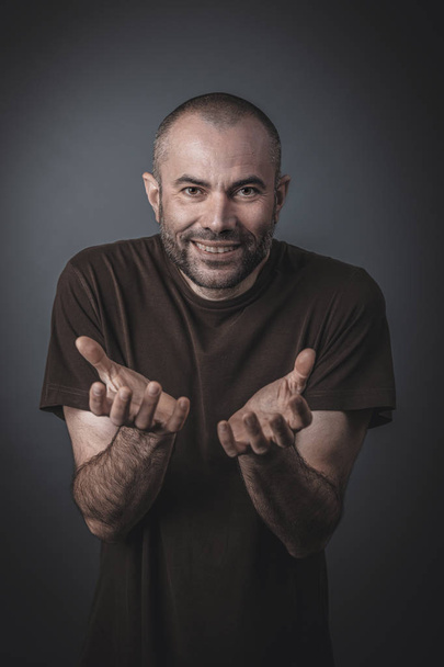 Portrait of a man with satisfied expression and clasped hands in - Foto, afbeelding