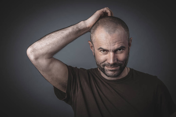 Portrait of a man scratching his head  - Fotografie, Obrázek