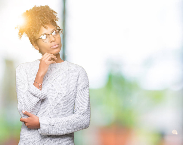 Krásná mladá africká americká žena na sobě zimní svetr přes samostatný pozadí s rukou na bradě přemýšlet o otázce, zamyšlený výraz. Usmívající se zamyšlenou tváři. Pochybnost koncept. - Fotografie, Obrázek