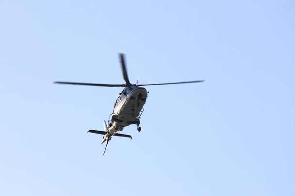 Hermoso helicóptero moderno en vuelo aislado contra el cielo
 - Foto, Imagen