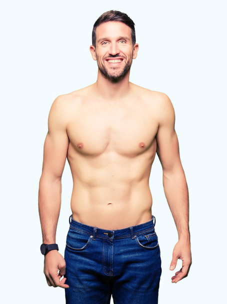 Handsome shirtless man showing nude chest with a happy and cool smile on face. Lucky person. - Photo, image