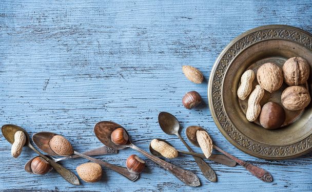Nuts on a beautiful background and vintage spoons. Background to - Photo, Image