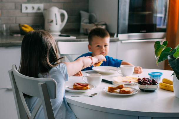 Happy family, sister and brother having breakfast at home - Valokuva, kuva