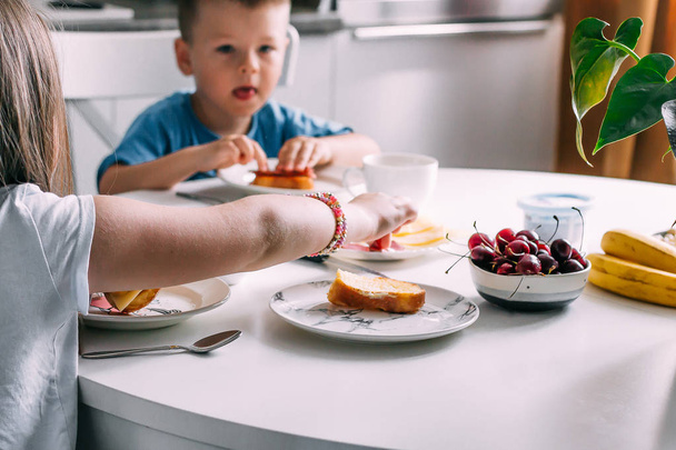 幸せな家族、姉妹と兄弟は自宅で朝食を食べる - 写真・画像