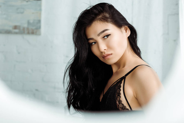 selective focus of sexy asian woman in lace underwear standing in bedroom  - Fotografie, Obrázek