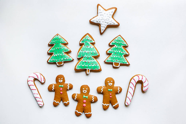 Handmade festive gingerbread cookies in the form of stars, snowflakes, people, socks, staff, mittens, Christmas trees, hearts for xmas and new year holiday on white paper background - Foto, imagen