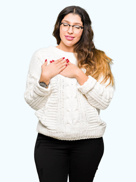 Young beautiful woman wearing glasses smiling with hands on chest with closed eyes and grateful gesture on face. Health concept. - Photo, image