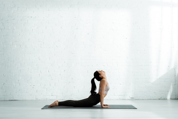 jolie femme thai faire de l'exercice sur tapis de yoga
  - Photo, image