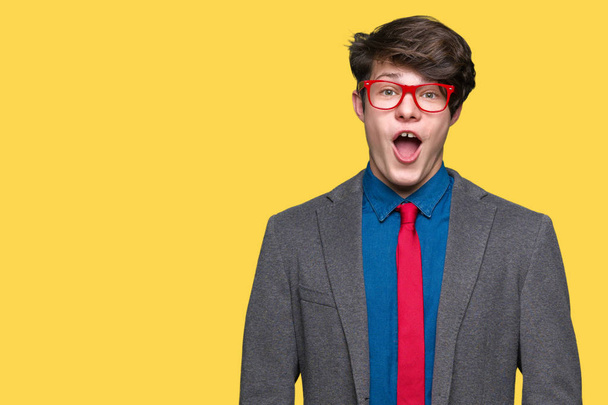 Young handsome business man wearing red glasses over isolated background afraid and shocked with surprise expression, fear and excited face. - Photo, Image