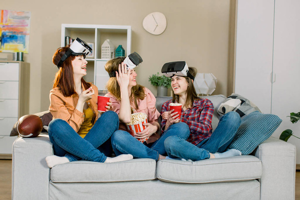 Young girls wearing virtual reality glasses indoor - Happy people having fun with new technology vr headset goggles - New generation mania trends concept - Фото, изображение